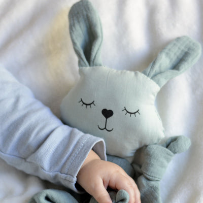 Close up image of baby holding aPunt Barcelona organic cotton bunny cuddle