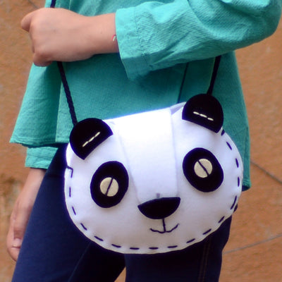 Side view of child wearing felt panda bag made from aPunt Barcelona do it yourself sewing kit