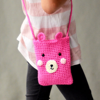 Close up image of girl's side whilst she wears the pink aPunt Barcelona crocheted bear bag