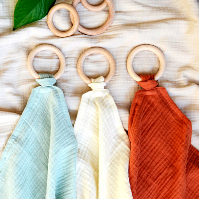 aPunt Barcelona wooden teething rings with organic cotton cuddles in ecru, ocean and argille colours